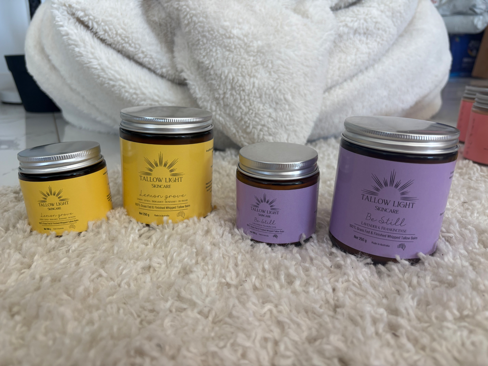 Tallow Light Skincare whipped tallow balm jars on a soft cream rug